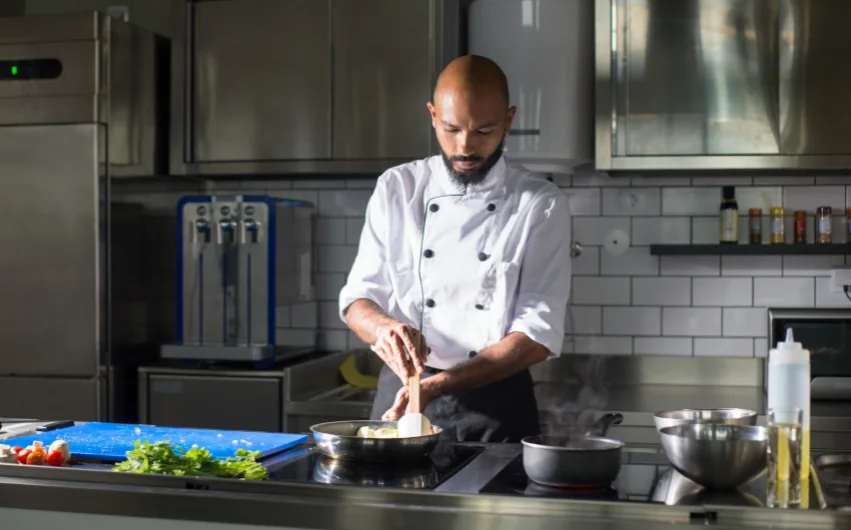 Un chef prépare un plat dans une cuisine professionnelle